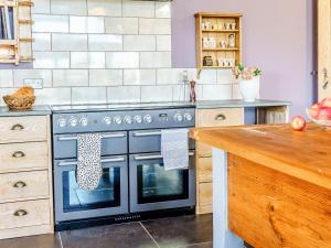 a kitchen with a black oven in a kitchen at Y Glowty Newydd - Uk31701 in Llandissilio