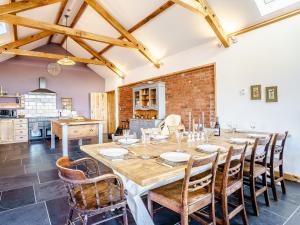 a kitchen and dining room with a large wooden table and chairs at Y Glowty Newydd - Uk31701 in Llandissilio