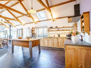 a large kitchen with wooden cabinets and a table at Y Glowty Newydd - Uk31701 in Llandissilio +27 photos