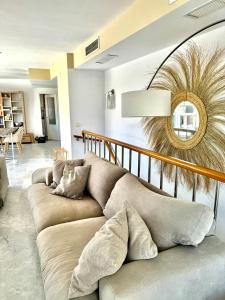a living room with a couch and a mirror at Penthouse Seven Oceans Moraira in Moraira