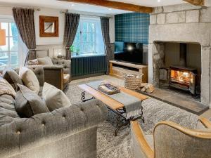 a living room with a couch and a fireplace at Hob Cote - Cottage in Heptonstall