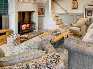 a living room with a fireplace with couches and a fire place at Hob Cote - Cottage in Heptonstall