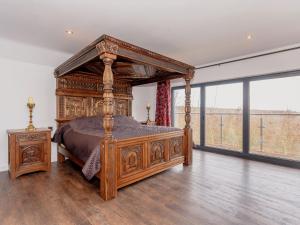a large wooden bed in a room with a large window at Olive Lodge in Melbourne