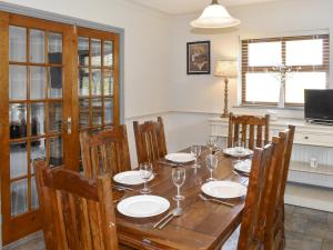 a dining room with a wooden table and chairs at Ty Fynnon Cottage-Uk2786 in Penmaen-mawr