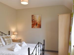 a bedroom with a bed and a painting on the wall at Ty Fynnon Cottage-Uk2786 in Penmaen-mawr