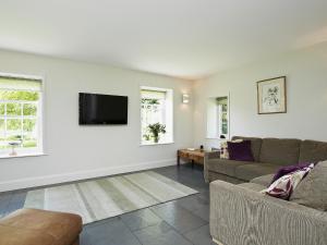 a living room with a couch and a flat screen tv at Curlew Barn in Sutton Bridge