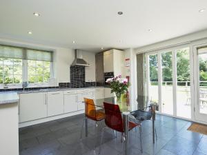 a kitchen with a glass table and chairs at Curlew Barn in Sutton Bridge