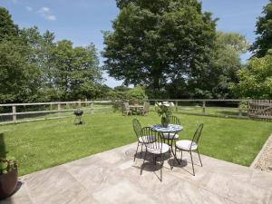 a patio with a table and chairs in a yard at Curlew Barn in Sutton Bridge