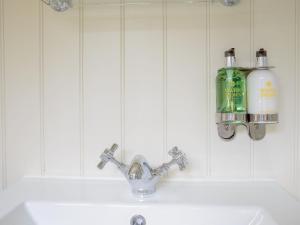 a bathroom sink with a faucet and two bottles of soap at Under Willows - Uk12608 in Burton Overy