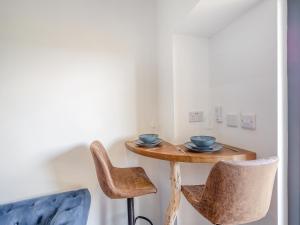 a small table with two bowls and two chairs at Beachfront Apartment in Rhos-on-Sea