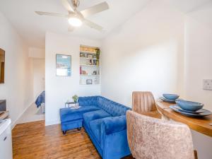 a living room with a blue couch and a table at Beachfront Apartment in Rhos-on-Sea