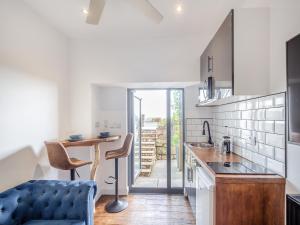 a kitchen with a table and a blue couch at Beachfront Apartment in Rhos-on-Sea