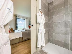 a bathroom with a shower and a bedroom at Clarsach in Big Sand