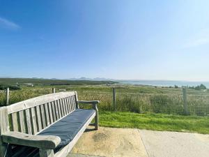 a wooden bench sitting on top of a field at Clarsach in Big Sand