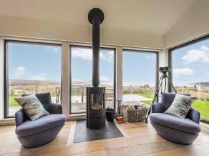 a living room with two chairs and a fireplace at Clarsach in Big Sand +22 photos