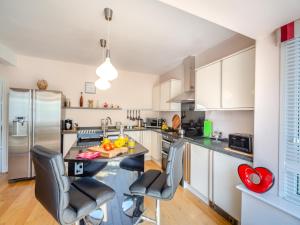 a kitchen with a table and chairs and a refrigerator at Waterside in Llandrillo-yn-Rhôs