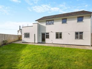 a white house with a lawn in front of it at Hafod Y Morfa - Uk48829 in Harlech