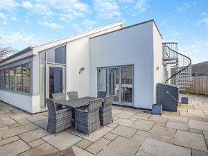 a house with a patio with a table and chairs at Hafod Y Morfa - Uk48829 in Harlech