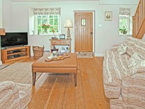 a living room with a couch and a coffee table at Pond View Cottage in Brantingham