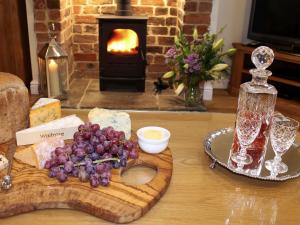 a table with a bunch of grapes on a cutting board at Pond View Cottage in Brantingham