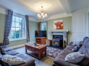a living room with a couch and a fireplace at Old Upper Gwestydd in Highgate