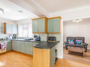 a kitchen with green cabinets and a counter top at Seacroft Lodge in Skegness +34 photos