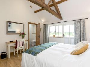 a bedroom with a bed and a desk and a window at The Old Dairy-Ukc2112 in Royal Wootton Bassett