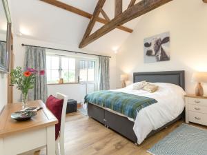 a bedroom with a bed and a table and a desk at The Old Dairy-Ukc2112 in Royal Wootton Bassett