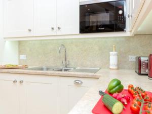 a kitchen with a sink and vegetables on a counter at The Old Dairy-Ukc2112 in Royal Wootton Bassett +8 photos