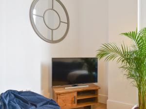 a living room with a tv and a mirror at Old Parish Hall in Ramsgate