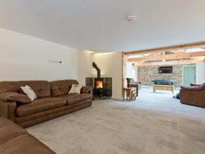 a living room with a couch and a fireplace at Eastlands Barn in East Barkwith