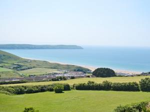 a green field with the ocean in the background at Soft Sands - Cottage in Woolacombe