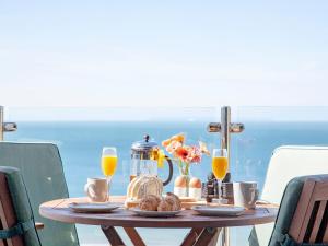 a table with food and orange juice and drinks on it at Soft Sands - Cottage in Woolacombe