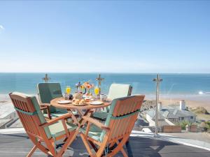 a table with chairs and a table with a view of the ocean at Soft Sands - Cottage in Woolacombe +30 photos