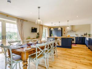 a kitchen and dining room with a wooden table and chairs at The Stables in Cheddar