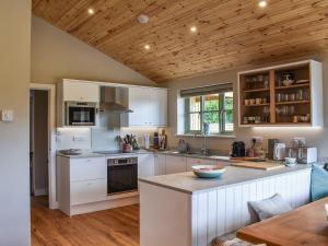 a kitchen with white appliances and a wooden ceiling at Hobby Lodge in Saint Columb Major
