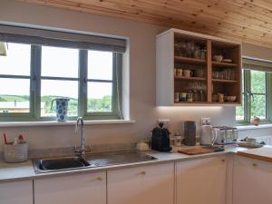 a kitchen with a sink and two windows at Hobby Lodge in Saint Columb Major +18 photos