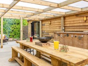 a wooden patio with a wooden table with a bowl on it at Old Shires Barn in Norton