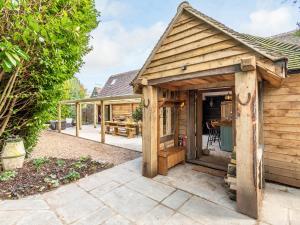 a wooden shed in a yard with a patio at Old Shires Barn in Norton