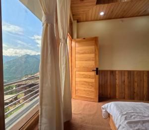 a bedroom with a bed and a window with a view at Jumanji homestay in Nagar