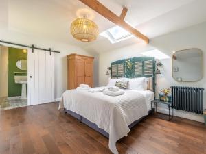 a bedroom with a large bed and a skylight at The Cowshed - Uk50803 in Cratfield
