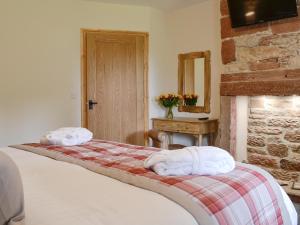 a bedroom with a bed with two towels on it at Holmegarth in Plumbland
