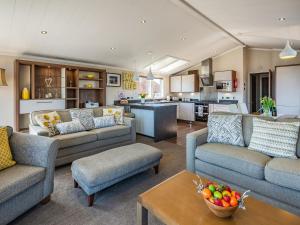a living room with two couches and a kitchen at Buff Lake - Uk37725 in Ingoldmells