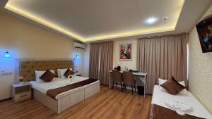 ein Hotelzimmer mit zwei Betten und einem Schreibtisch in der Unterkunft AKS Hotel in Taschkent + 96 Fotos