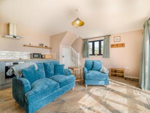 a living room with a blue couch and two chairs at The Old Stable At Henley View in Draycott