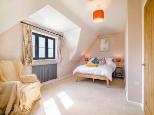 a bedroom with a bed and a chair and a window at The Old Stable At Henley View in Draycott