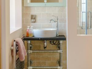 a bathroom with a white sink on a counter at The Cornstore - Uk32513 in Marloes