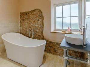 a bathroom with a large tub and a sink at The Cornstore - Uk32513 in Marloes
