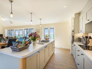 a kitchen with white cabinets and a large counter top at Lizzie's Cottage in Skendleby