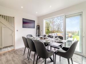 a dining room with a table and chairs and a large window at Longridge in Peldon